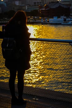 Woman standing on a large pier at dusk. Shooting Location: Yokohama-city kanagawa prefecture