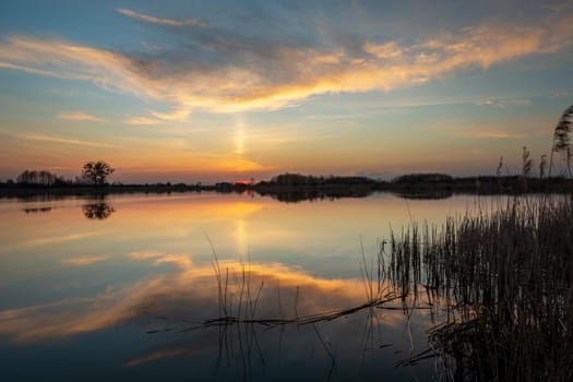 Reflection of the evening cloud in the lake water, spring evening