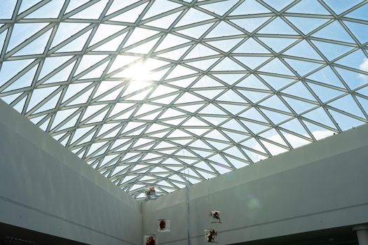 Transparent glass roof of a modern shopping center with sunlight