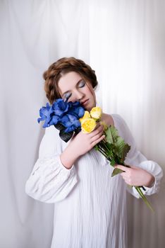 Portrait Caucasian Ukrainian girl in a white dress and flowers on white background . Symbol of the Ukrainian yellow blue colour. The calm lady is asleep. Concept - Stop War in Ukraine.