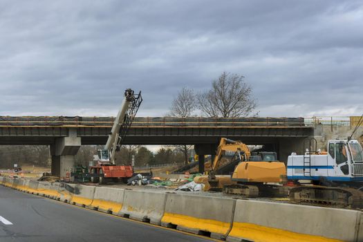 Construction for renewing damages on pillars of concrete bridge of a under renovation road modern road interchange in USA