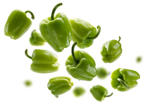 Green paprika levitates on a white background.