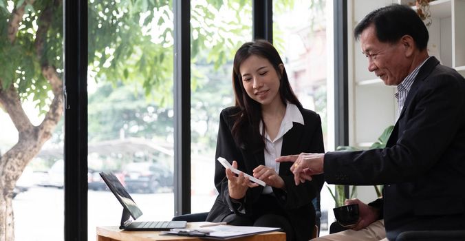 Middle aged businessman having an informal meeting with his financial manager. asian businesspeople concept..