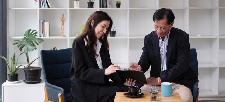 Businesswoman manager consultant speaks to middle-aged businessman clients offering banking insurance services. Agreement to teach internships or convince clients at a business office meeting