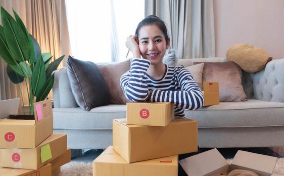 Small Business SME entrepreneur of Young Asian women working with laptop for Online shopping at home,Cheerful and Happy with box for packaging in home,Own Business Start up for Business Online.