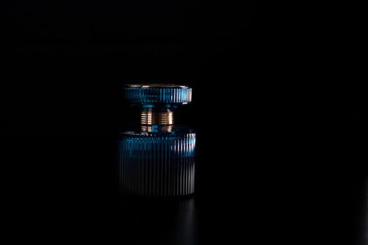 Blue perfume bottle on black background
