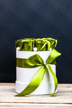 Green roses in a round luxury present box. Bouquet of flowers in a paper box isolated.