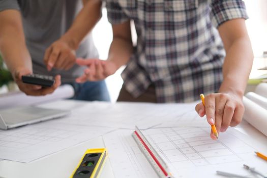 Young man was designing a building or architecture with a ruler, pen, pencil, tape measure, architect hat and other equipment.