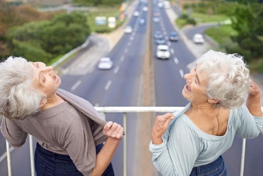 Two senior women flashing their chests at passers-by.