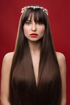 Beauty portrait of a young beautiful brunette girl with long black straight hair and wreath on it