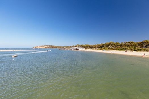 The idyllic Barwon River Beach and Barwon Heads Bridge on a hot summer's day in Barwon Heads, Victoria, Australia
