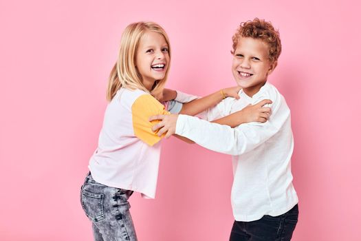 funny children hug casual clothes pink background. High quality photo