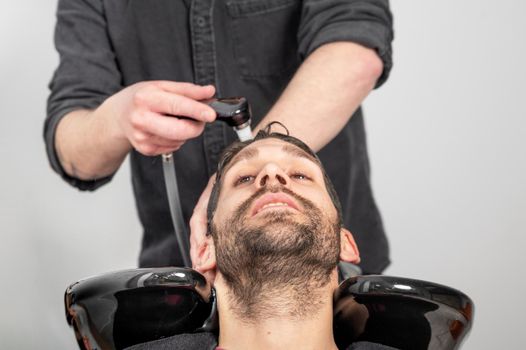 Barber shop. Hairdresser man washes client head in barbershop. High quality photography