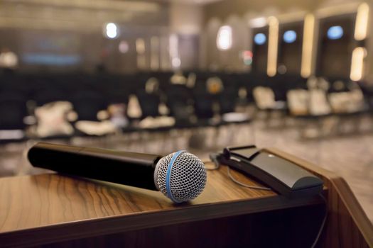 There is a microphone on the table against the background of an empty hall.