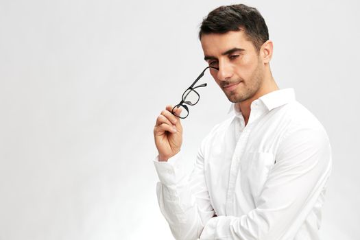 man in a white shirt, glasses, a pensive look, self-confidence business and office concept. High quality photo