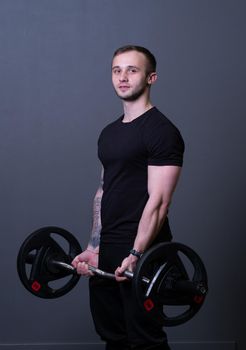Guy with a barbell in a black fitness T-shirt muscular bodybuilder attractive fit, In the afternoon strength athlete in sport for healthy weightlifting, caucasian triceps. Man young motivation, equipment arm