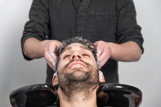 Barber shop. Hairdresser man washes client head in barbershop. High quality photography