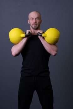 Guy with a yellow kettlebell gym anonymous young man, from fit effort in painted and rubber sportive, malaysian fitness. Healthy bent cardio, building hiit