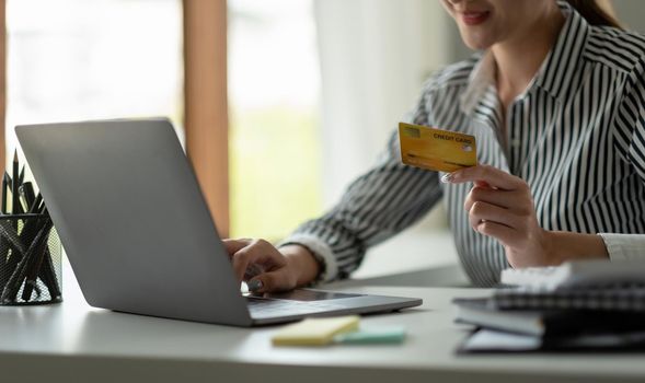 technology, asian woman online shopping concept - happy smiling woman with laptop computer and credit card at home.