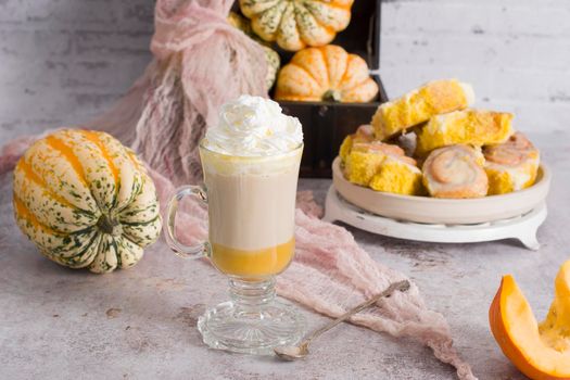 pumpkin cinnabons and latte for dessert, holiday table with pastries, home sweet home, autumn menu. High quality photo