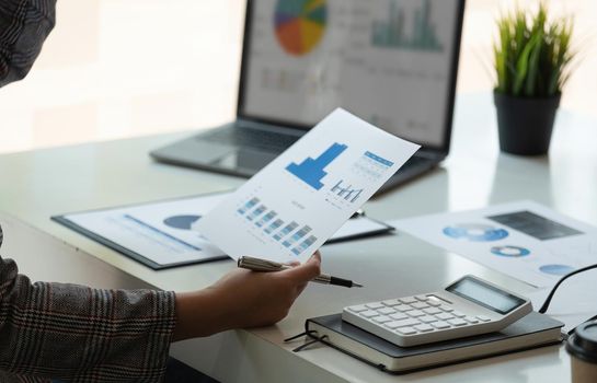 Business woman using calculator for do math finance on wooden desk in office and business working background, tax, accounting, statistics and analytic research concept.