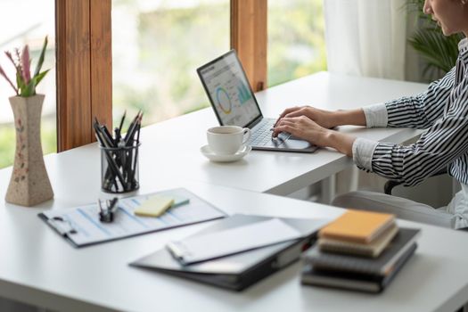 Portrait of young asian woman working with laptop at home office.