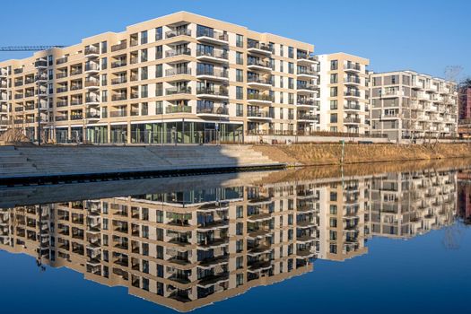 Modern apartment buildings reflecting in a canal seen in Berlin, Germany