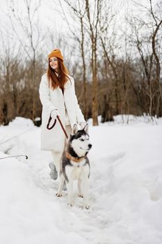 cheerful woman winter clothes walking the dog in the snow winter holidays. High quality photo