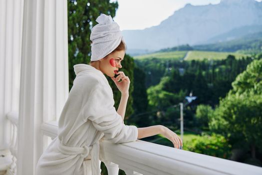 Woman in a bathrobe stands on the balcony of the hotel unaltered. High quality photo