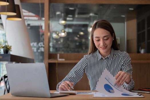 Business woman using calculator for do math finance on wooden desk in office, tax, accounting, statistics home accounring concept