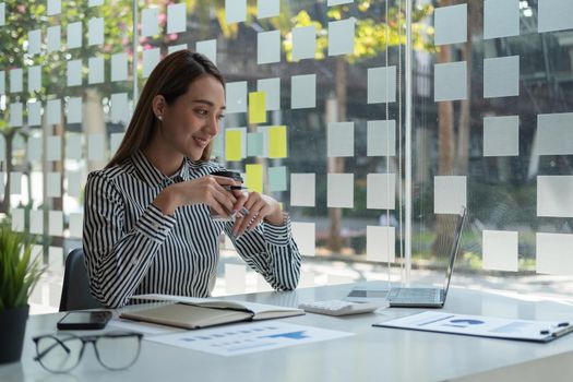 Portrait Of Attractive Asian Businesswoman Working On Laptop for marketing plan.