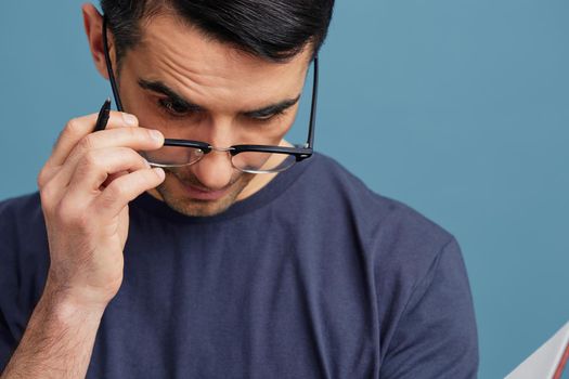 handsome man blue t-shirt with notepad glasses idea pen cropped view. High quality photo