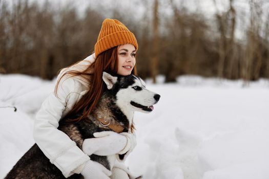 portrait of a woman outdoors in a field in winter walking with a dog winter holidays. High quality photo