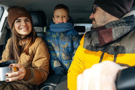 Mother, father and child traveling by car on a vacation to the mountains in winter, close up