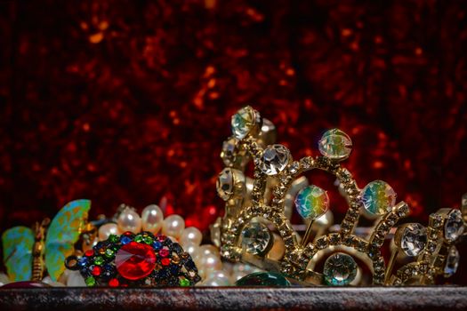 Part of bijouterie and crown on a red background.
