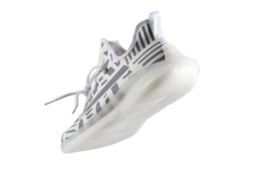 Sport shoes. White fabric trainers with gray reflective stripes.