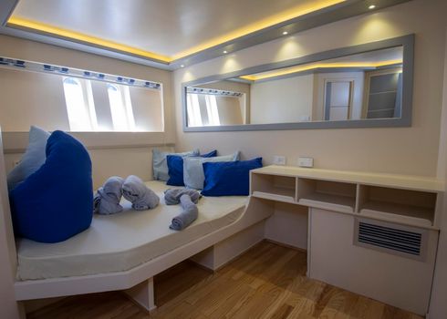 Interior decor of cabin bedroom on luxury sailing yacht with double bed
