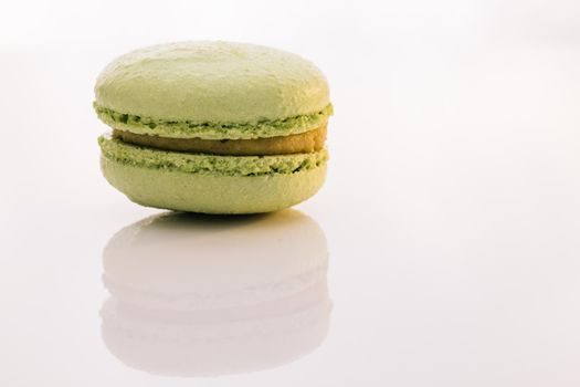 Green macaron pastries on white background. Colorful cake macaroons. Traditional French macaroon. Food concept