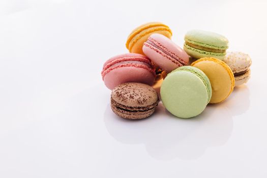 Macarons dessert. Multicolor macarons French macaroon greedy pastry on white background. Food concept.