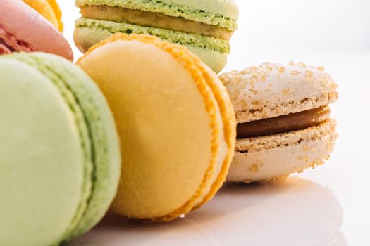 Multicolor macarons , French macaroon, greedy pastry. Close up of Multicolored Macarons Cookies. Food concept