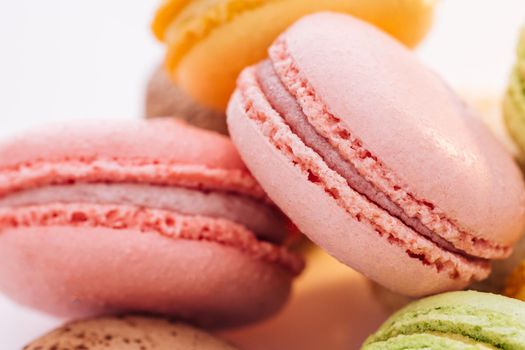 Close up of multicolor macarons French macaroon greedy pastry on white background. Macarons dessert. Food concept.