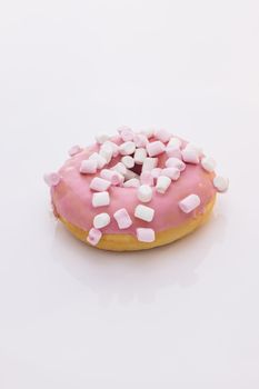 Bright and colorful sprinkled donut close-up shot on a white background. Assortment of donuts of different flavors. Pink glazed and sprinkles donut.