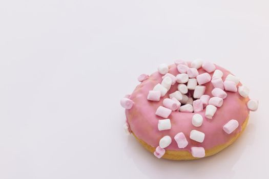 Bright and colorful sprinkled donut on a white background. Assortment of donuts of different flavors. Pink glazed marshmallow donut.
