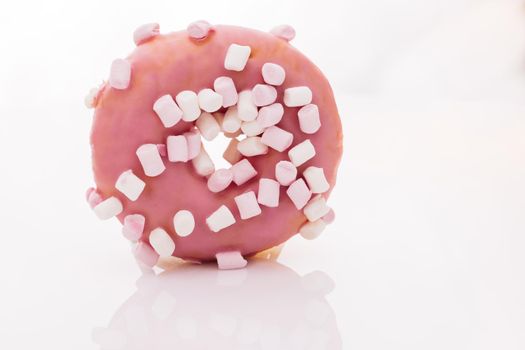 Assortment of donuts of different flavors. Pink glazed marshmallow donut. Bright and colorful sprinkled donut on a white background.