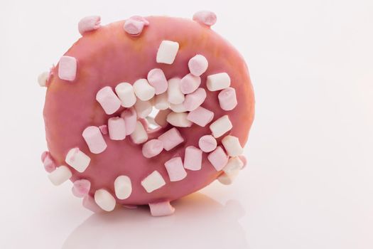 Pink glazed marshmallow donut. Bright and colorful sprinkled donut on a white background. Assortment of donuts of different flavors.