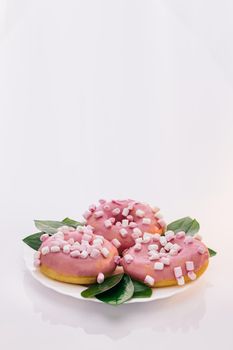 Pink glazed and sprinkles donuts. White tasty delicious sweet donut with colorful sprinkles on white background. Dessert. Colorful frosted pink doughnut. Assorted donuts.