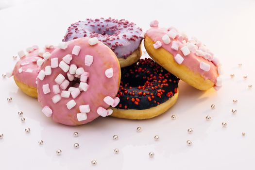 Donuts of white background. concept art. Donuts of different colors. Glazed sweet desserts. Fast food, Bakery concept. Various colorful donuts. Chocolate, purple, pink donuts