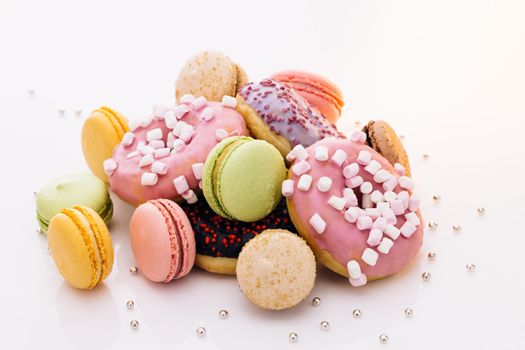 Macaroons and donuts on a white background. Macaroons, sweets. Many multi-colored macaroons donuts with different tastes, dessert.