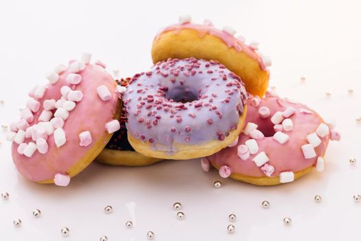 Donuts of different colors. Glazed sweet desserts. Fast food, Bakery concept. Various colorful donuts. Chocolate, purple, pink donuts. Donuts of white background. concept art.