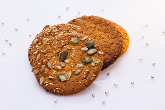 Cookies on white background. Food, eating concept. Cookies with pieces of sunflower pumpkin seeds. Eat oatmeal cookies.
